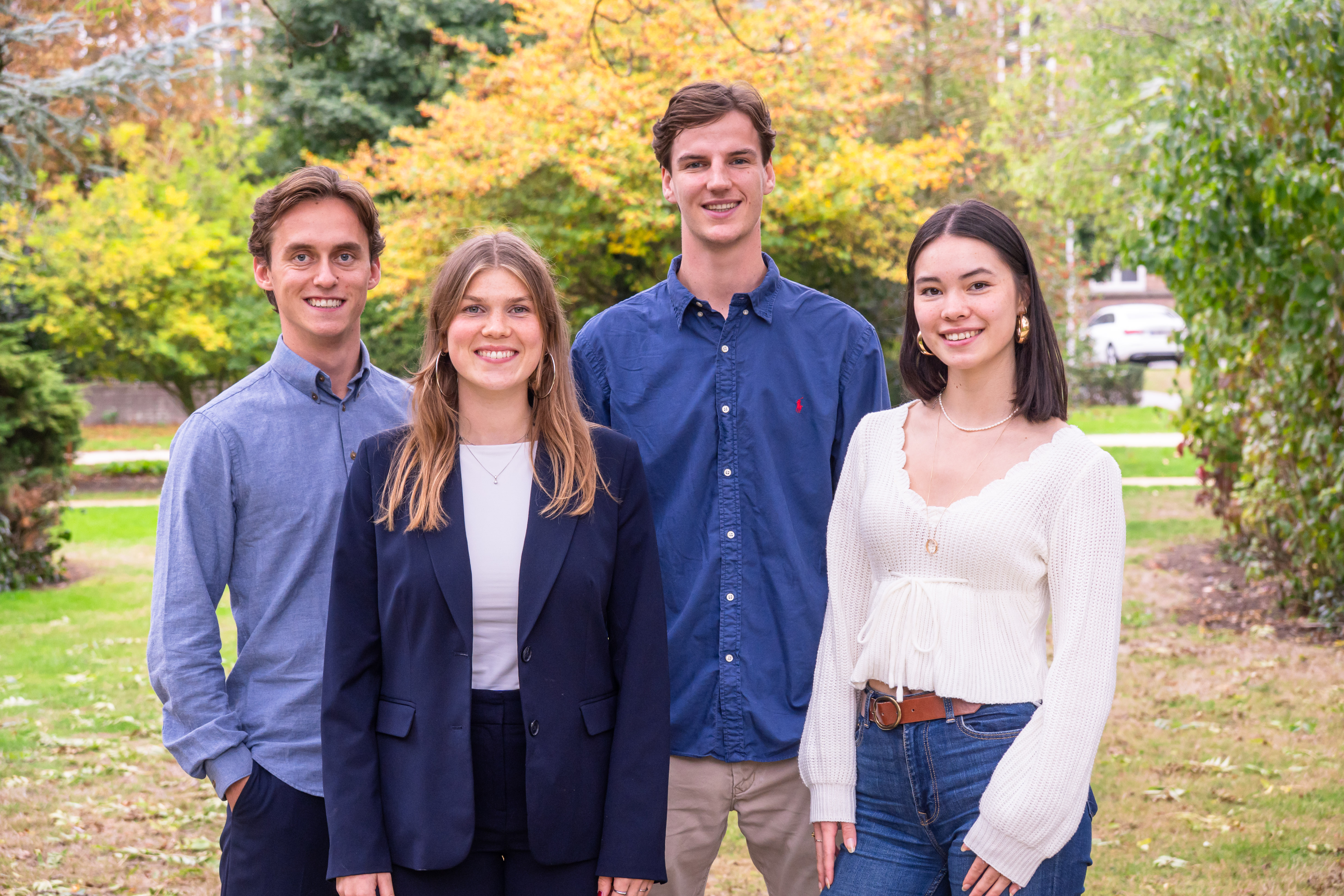 3 medewerkers van Kojac die om een stoel heen staan.
