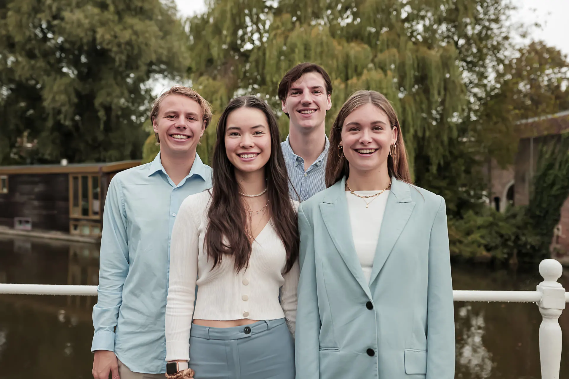 3 medewerkers van Kojac die om een stoel heen staan.